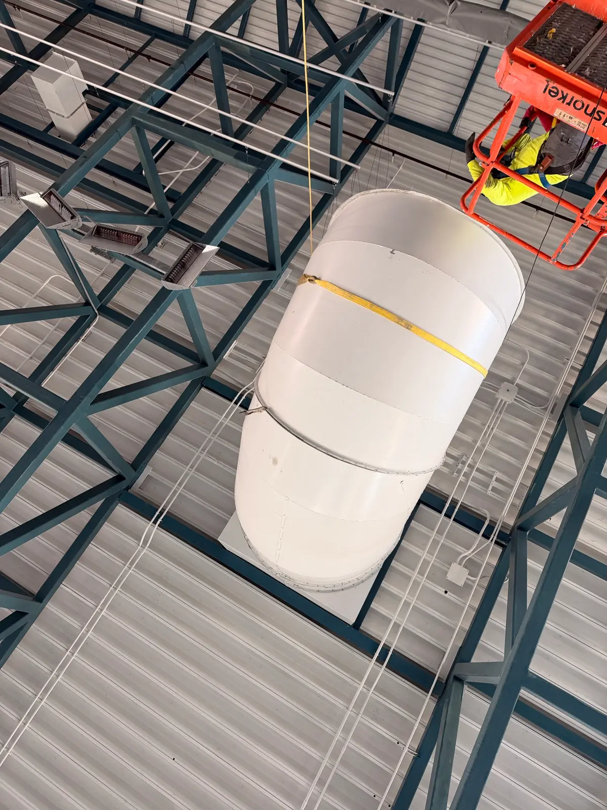 Large round duct section hung from the natatorium roof trusses