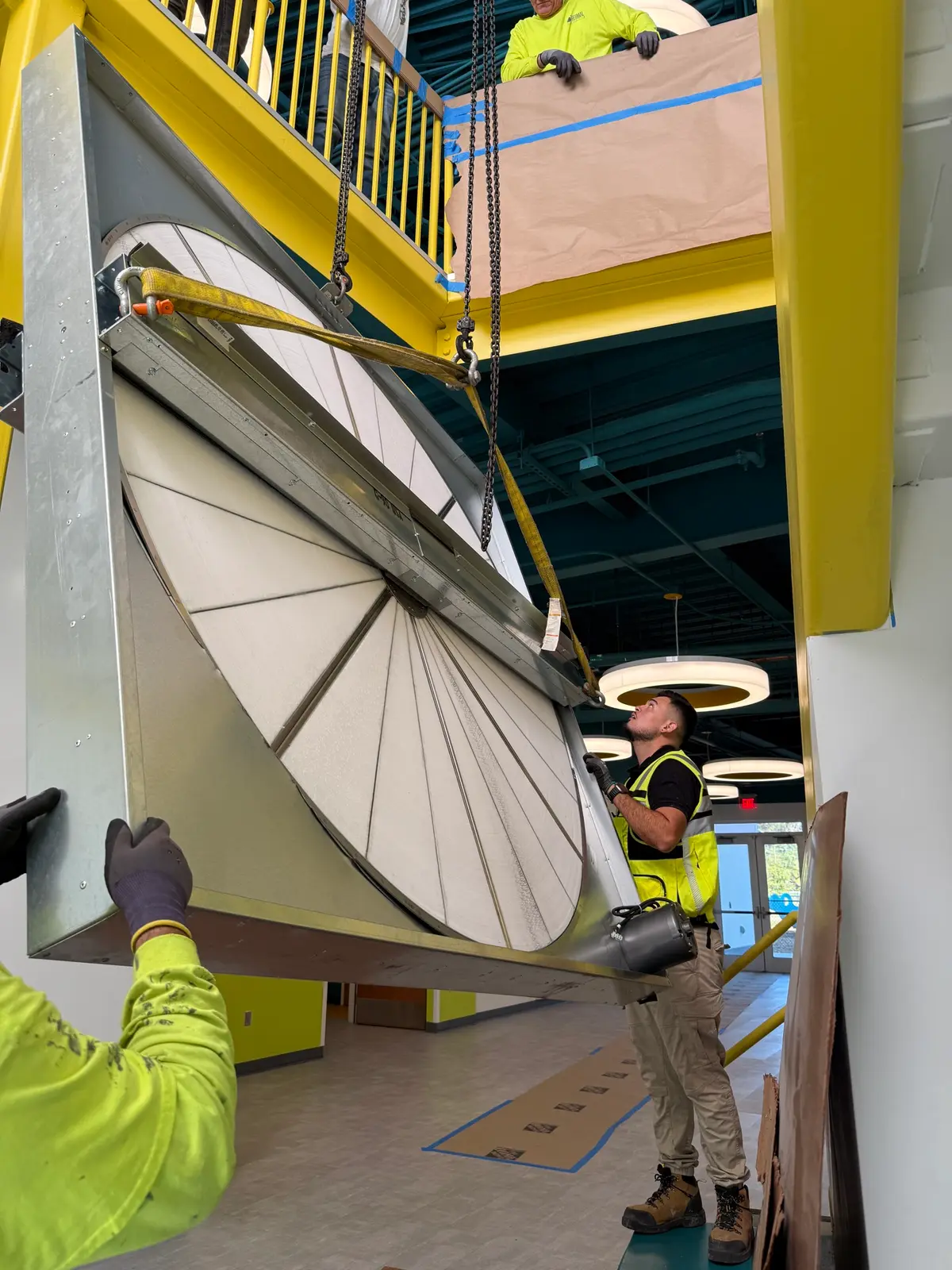 CEOS crew rigging a large air-handling component into place