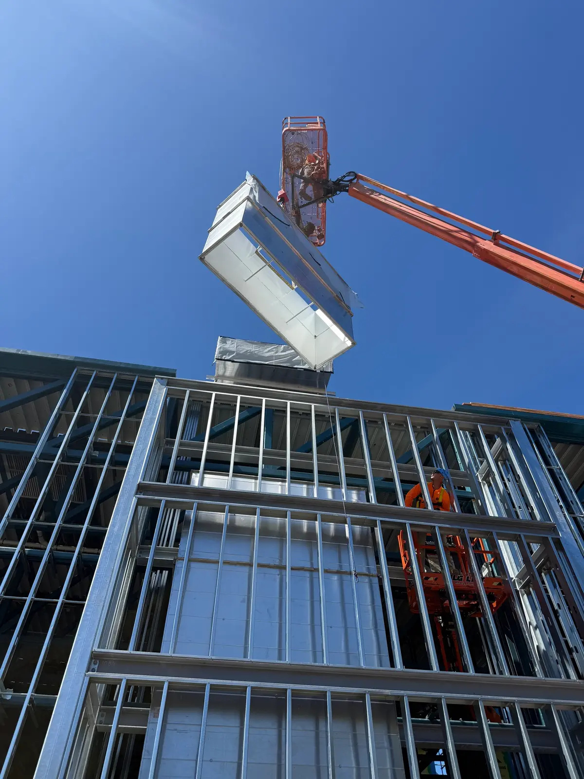 HVAC unit lifted by boom over the Long Center steel frame
